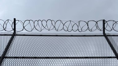 Çitin üstünde dikenli tel var. Kentsel güvenlik çitleri.