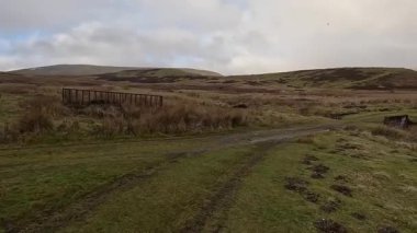 İskoçya 'nın Crieff yakınlarındaki Meall Tarsuinn dağında yürüyüş. Doğada tepe yürüyüşü, ilkbaharda açık hava, kar ve fundalık. Yuvarlanan dağlar