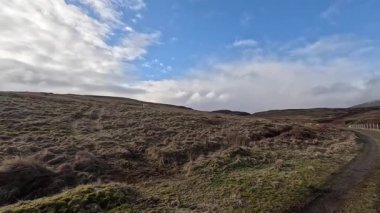 İskoçya 'nın Crieff yakınlarındaki Meall Tarsuinn dağında yürüyüş. Doğada tepe yürüyüşü, ilkbaharda açık hava, kar ve fundalık. Yuvarlanan dağlar