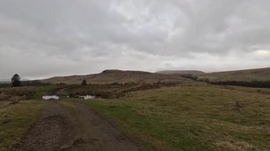 İskoçya 'nın Crieff yakınlarındaki Meall Tarsuinn dağında yürüyüş. Doğada tepe yürüyüşü, ilkbaharda açık hava, kar ve fundalık. Yuvarlanan dağlar