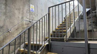 Metal basamaklar yeraltından otoparka doğru gidiyor. Grunge kentsel çevresi ve aşağıya inen çelik basamaklar. Endüstriyel vahşi modernizm.