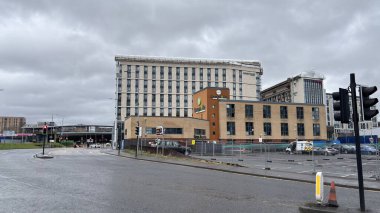 Glasgow şehir merkezinde ikonik binalar ve yağmurda ünlü turistik yerler görülüyor. Sıkıcı bulutlu bir gün. Kirli İskoç şehri