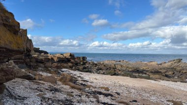İskoçya 'da Edinburgh yakınlarındaki Aberlady Plajı. Açık bir bahar gününde rüzgârlı bir sahil. Hafif bulutlar, altın kum, silip süpüren sahil ve deniz kıyıları