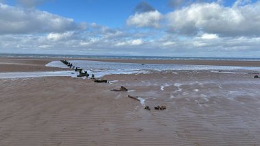 İskoçya 'da Edinburgh yakınlarındaki Aberlady Plajı. Açık bir bahar gününde rüzgârlı bir sahil. Hafif bulutlar, altın kum, silip süpüren sahil ve deniz kıyıları