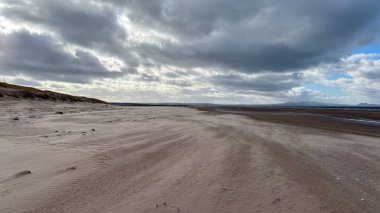 İskoçya 'da Edinburgh yakınlarındaki Aberlady Plajı. Açık bir bahar gününde rüzgârlı bir sahil. Hafif bulutlar, altın kum, silip süpüren sahil ve deniz kıyıları