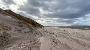 İskoçya 'da Edinburgh yakınlarındaki Aberlady Plajı. Açık bir bahar gününde rüzgârlı bir sahil. Hafif bulutlar, altın kum, silip süpüren sahil ve deniz kıyıları