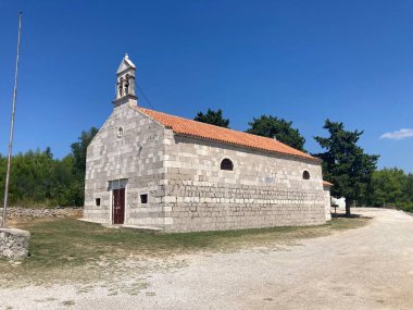 Zadar yakınlarındaki Ugljan Adası 'ndaki Karların Leydisi Ortaçağ Taş Kilisesi. Güneşli bir gün tarihi bina