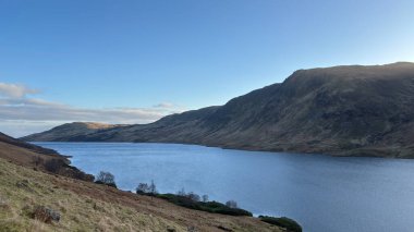 İskoçya 'nın dağlık kırsal kesimindeki göl tareti İskoçya' nın dağlık arazi manzarası tipik kenevir ve otlaklarla kaplı.