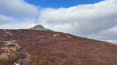 Glen Turret ve İskoç Dağları 'ndaki Loch Tarret yakınlarındaki Choinneachain Tepesi' ndeki taş cairn. İskoçya 'da tipik fundalık ve çayır manzarası