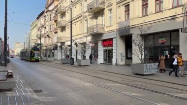 Pozna 'da sokaklarda seyahat eden bir tramvay. Poznan 'ın toplu taşıma sistemi. Polonya tramvayları. Güneşli bir günde sokak manzarası