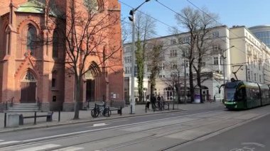 Pozna 'da sokaklarda seyahat eden bir tramvay. Poznan 'ın toplu taşıma sistemi. Polonya tramvayları. Güneşli bir günde sokak manzarası