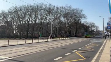 Pozna 'da sokaklarda seyahat eden bir tramvay. Poznan 'ın toplu taşıma sistemi. Polonya tramvayları. Güneşli bir günde sokak manzarası