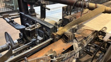 Antika dokuma tezgahı makinesi metal işleme işleme kumaşı üretiyor. Manufaktura Müzesi