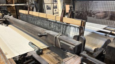 Antika dokuma tezgahı makinesi metal işleme işleme kumaşı üretiyor. Manufaktura Müzesi