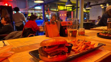 Son moda bir restoranda büyük bir hamburger ve patates kızartması. Güzel yemek tasarımcısı şef yemekleri. Salata ve patates kızartmalı biftek.