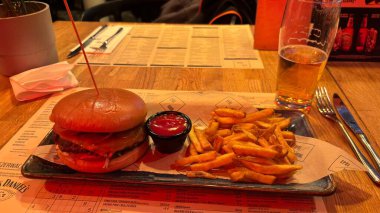 Son moda bir restoranda büyük bir hamburger ve patates kızartması. Güzel yemek tasarımcısı şef yemekleri. Salata ve patates kızartmalı biftek.