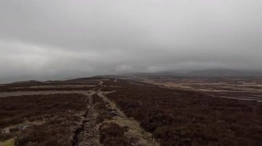 İskoç kırlarını ve tepelerini süpürdü. Perthshire sıradağları. Cnoc Beithe tepesi. Otlaklar, koyunlar ve akan su. Dağlık nehir bulutlu vahşi yerleri yakıyor.