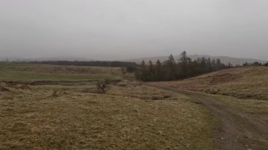 İskoç kırlarını ve tepelerini süpürdü. Perthshire sıradağları. Cnoc Beithe tepesi. Otlaklar, koyunlar ve akan su. Dağlık nehir bulutlu vahşi yerleri yakıyor.