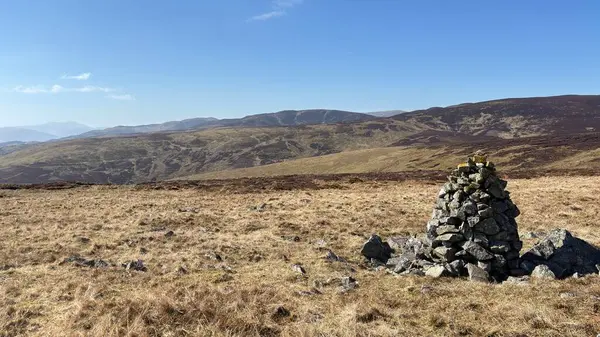 Perthshire 'ın İskoç Dağları' ndaki tepelerin zirvesini oluşturan dağ kairn taşı yığını. Açık tepeler, manzaralı tepe. Güzel İskoçya açık arazileri.