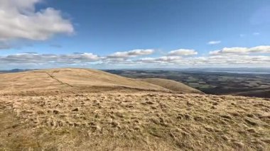 Glen Devon 'da Perthshire' daki Loch Tarret Barajı 'nın yanında yürüyorum. İskoç kırları ve tepeleri. Dağ sırası. Otlaklar, koyunlar ve akan su. İskoçya İskoç nehri aydınlık güneşli bir günde vahşi yerleri yakar.
