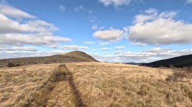 Glen Devon 'da Perthshire' daki Loch Tarret Barajı 'nın yanında yürüyorum. İskoç kırları ve tepeleri. Dağ sırası. Otlaklar, koyunlar ve akan su. İskoçya İskoç nehri aydınlık güneşli bir günde vahşi yerleri yakar.