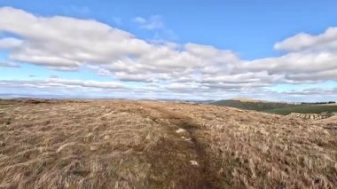 Glen Devon 'da Perthshire' daki Loch Tarret Barajı 'nın yanında yürüyorum. İskoç kırları ve tepeleri. Dağ sırası. Otlaklar, koyunlar ve akan su. İskoçya İskoç nehri aydınlık güneşli bir günde vahşi yerleri yakar.