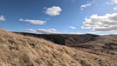 Glen Devon 'da Perthshire' daki Loch Tarret Barajı 'nın yanında yürüyorum. İskoç kırları ve tepeleri. Dağ sırası. Otlaklar, koyunlar ve akan su. İskoçya İskoç nehri aydınlık güneşli bir günde vahşi yerleri yakar.
