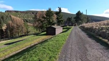 Glen Devon 'da Perthshire' daki Loch Tarret Barajı 'nın yanında yürüyorum. İskoç kırları ve tepeleri. Dağ sırası. Otlaklar, koyunlar ve akan su. İskoçya İskoç nehri aydınlık güneşli bir günde vahşi yerleri yakar.