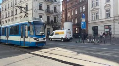 Krakow sokaklarında seyahat eden modern Polonya tramvayları. Polonya 'nın Krakw kentinin şehir manzarası. Polonya, ünlü sokak binaları yerleştirdi