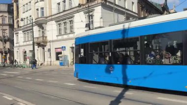Krakow sokaklarında seyahat eden modern Polonya tramvayları. Polonya 'nın Krakw kentinin şehir manzarası. Polonya, ünlü sokak binaları yerleştirdi