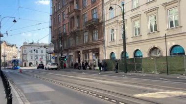 Krakow sokaklarında seyahat eden modern Polonya tramvayları. Polonya 'nın Krakw kentinin şehir manzarası. Polonya, ünlü sokak binaları yerleştirdi