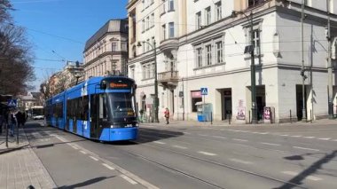 Krakow sokaklarında seyahat eden modern Polonya tramvayları. Polonya 'nın Krakw kentinin şehir manzarası. Polonya, ünlü sokak binaları yerleştirdi