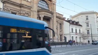 Krakow sokaklarında seyahat eden modern Polonya tramvayları. Polonya 'nın Krakw kentinin şehir manzarası. Polonya, ünlü sokak binaları yerleştirdi