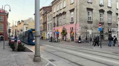 Krakow sokaklarında seyahat eden modern Polonya tramvayları. Polonya 'nın Krakw kentinin şehir manzarası. Polonya, ünlü sokak binaları yerleştirdi