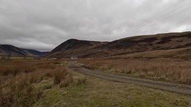 Perthshire dağlarında İskoç yamaç yürüyüşü. Geniş açık İskoçya vahşi doğası yuvarlanan tepeleri açıyor. Uzun mesafe macera yürüyüşü. Kış gölü ve Glen.