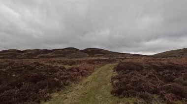 Perthshire dağlarında İskoç yamaç yürüyüşü. Geniş açık İskoçya vahşi doğası yuvarlanan tepeleri açıyor. Uzun mesafe macera yürüyüşü. Kış gölü ve Glen.
