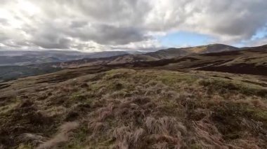 Perthshire dağlarında İskoç yamaç yürüyüşü. Geniş açık İskoçya vahşi doğası yuvarlanan tepeleri açıyor. Uzun mesafe macera yürüyüşü. Kış gölü ve Glen.