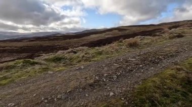 Perthshire dağlarında İskoç yamaç yürüyüşü. Geniş açık İskoçya vahşi doğası yuvarlanan tepeleri açıyor. Uzun mesafe macera yürüyüşü. Kış gölü ve Glen.