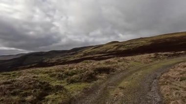 Perthshire dağlarında İskoç yamaç yürüyüşü. Geniş açık İskoçya vahşi doğası yuvarlanan tepeleri açıyor. Uzun mesafe macera yürüyüşü. Kış gölü ve Glen.