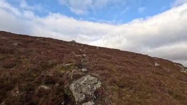 Perthshire dağlarında İskoç yamaç yürüyüşü. Geniş açık İskoçya vahşi doğası yuvarlanan tepeleri açıyor. Uzun mesafe macera yürüyüşü. Kış gölü ve Glen.