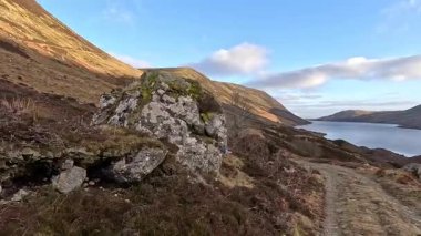 Perthshire dağlarında İskoç yamaç yürüyüşü. Geniş açık İskoçya vahşi doğası yuvarlanan tepeleri açıyor. Uzun mesafe macera yürüyüşü. Kış gölü ve Glen.