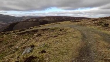Perthshire dağlarında İskoç yamaç yürüyüşü. Geniş açık İskoçya vahşi doğası yuvarlanan tepeleri açıyor. Uzun mesafe macera yürüyüşü. Kış gölü ve Glen.