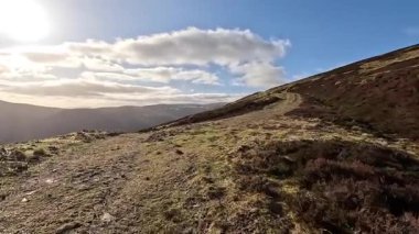 Perthshire dağlarında İskoç yamaç yürüyüşü. Geniş açık İskoçya vahşi doğası yuvarlanan tepeleri açıyor. Uzun mesafe macera yürüyüşü. Kış gölü ve Glen.