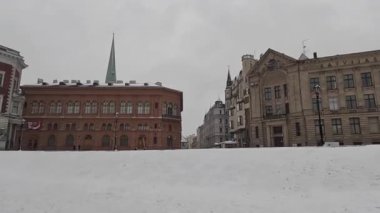 Riga, Letonya 'nın başkentindeki şehir manzarası soğuk kış aylarında. Kar ve buz. Şehir binaları ve evler. Sokak manzaralı turizm merkezi