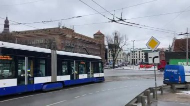Soğuk kış aylarında Riga, Letonya 'nın başkentinde sokak manzaralı bir tramvay. Kar ve buz. Sokak manzaralı turizm merkezi