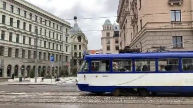 Soğuk kış aylarında Riga, Letonya 'nın başkentinde sokak manzaralı bir tramvay. Kar ve buz. Şehir binaları ve evler. 