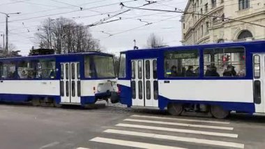 Soğuk kış aylarında Riga, Letonya 'nın başkentinde sokak manzaralı bir tramvay. Kar ve buz. Şehir binaları ve evler. 