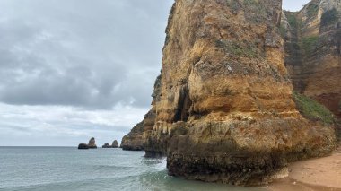 Lagos yakınlarındaki Portekiz 'in Algarve sahil şeridinde güzel sahil kayalıkları, kayalar ve plajlar. Okyanus dalgaları kumtaşı yapıları turistik eğlence mağaraları geziler kumsal hayatı kumları.