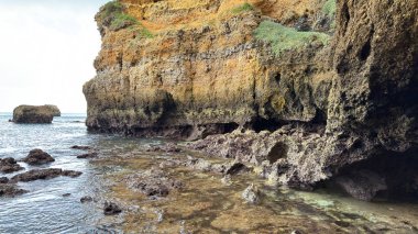 Lagos yakınlarındaki Portekiz 'in Algarve sahil şeridinde güzel sahil kayalıkları, kayalar ve plajlar. Okyanus dalgaları kumtaşı yapıları turistik eğlence mağaraları geziler kumsal hayatı kumları.