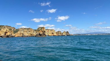 Lagos yakınlarındaki Portekiz 'in Algarve sahil şeridinde güzel sahil kayalıkları, kayalar ve plajlar. Okyanus dalgaları kumtaşı yapıları turistik eğlence mağaraları geziler kumsal hayatı kumları.